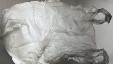 The image of a crumpled, translucent plastic bag floats against a blurred grey background.